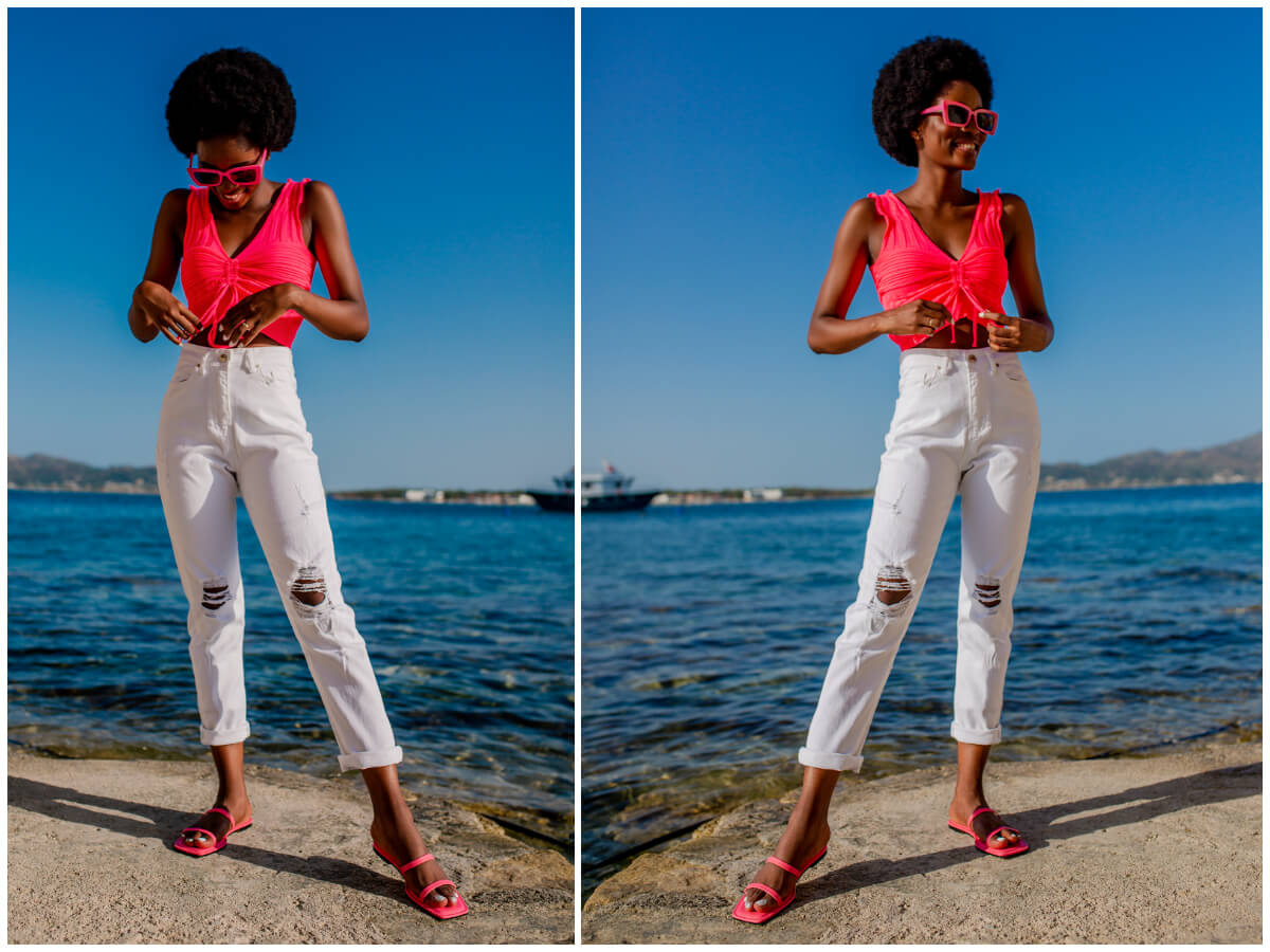 Modelka stoi na tle morza i promuje białe jeansy damskie z dziurami