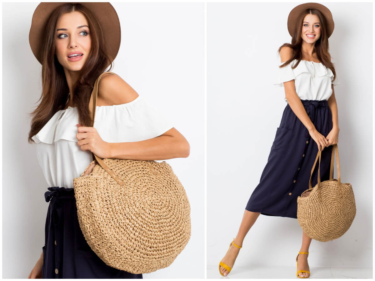 Pleciona okrągła torba w stylizacji na modelce, która promuje modne torebki na lato